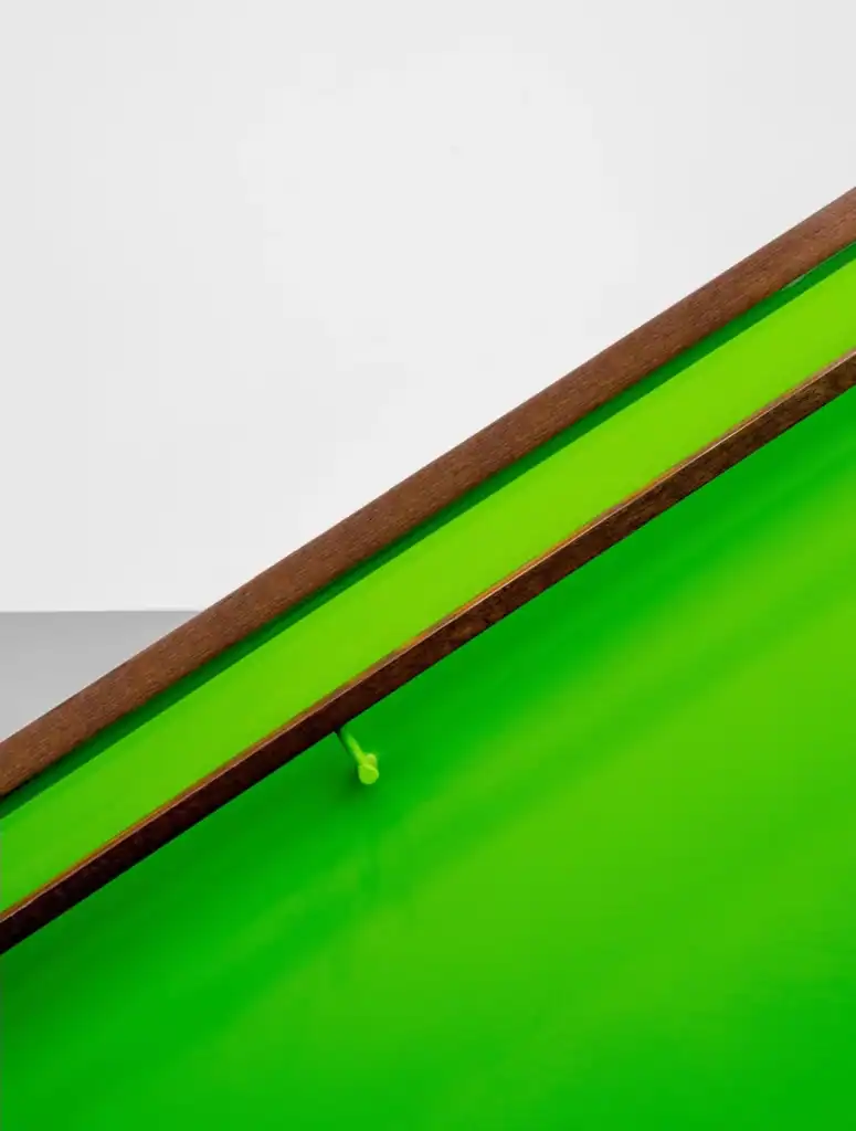 Bright green skateboard with wooden edges, detailed view of the deck's design.